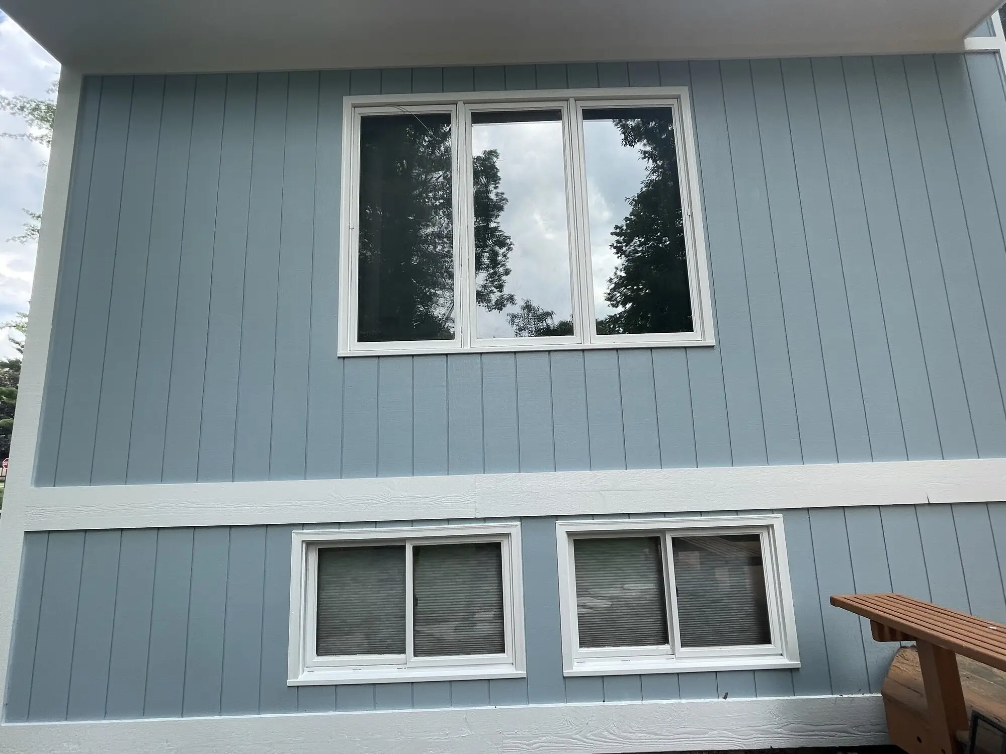 Blue grey board and batten siding with fresh white window trim