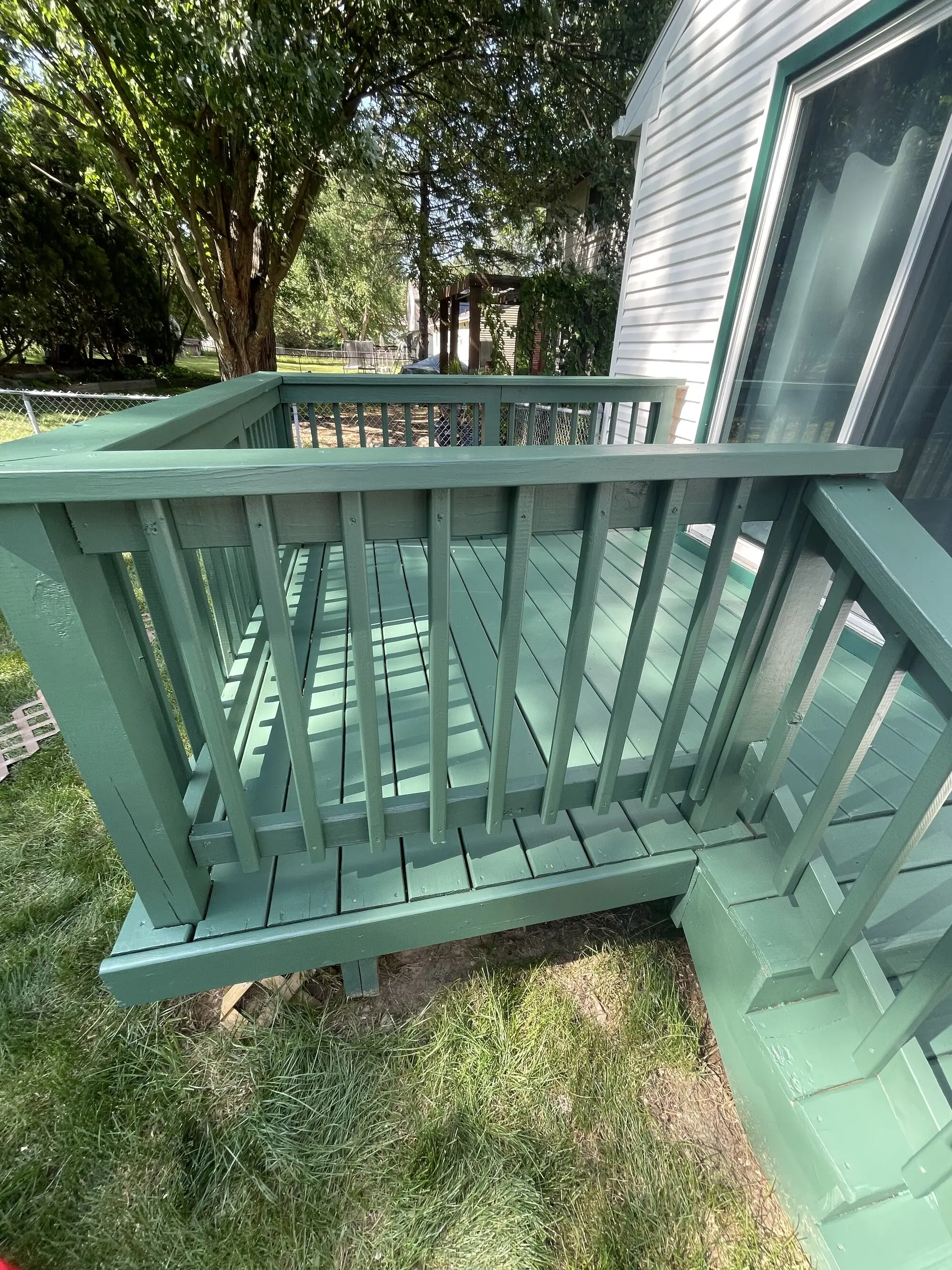 Teal painted porch railing and skirting on a raised deck